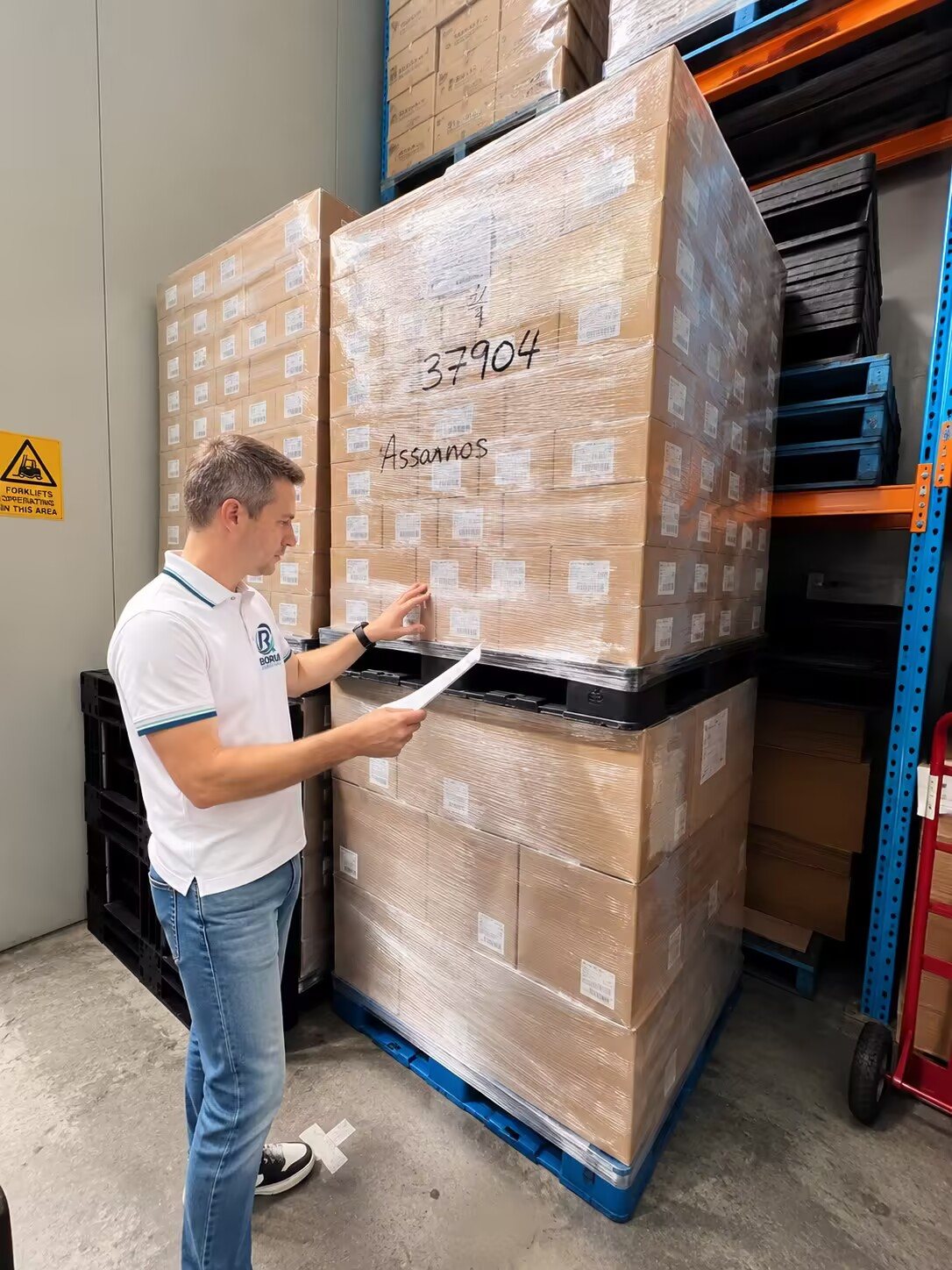 Borui team member checking a wrapped pallet against the packing list in our warehouse